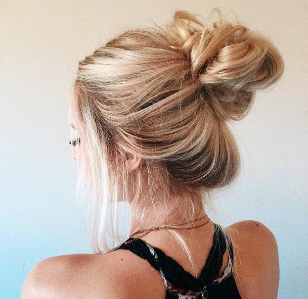 Back View Womans Loosely Blonde Hair In Top Knot Hairstyle