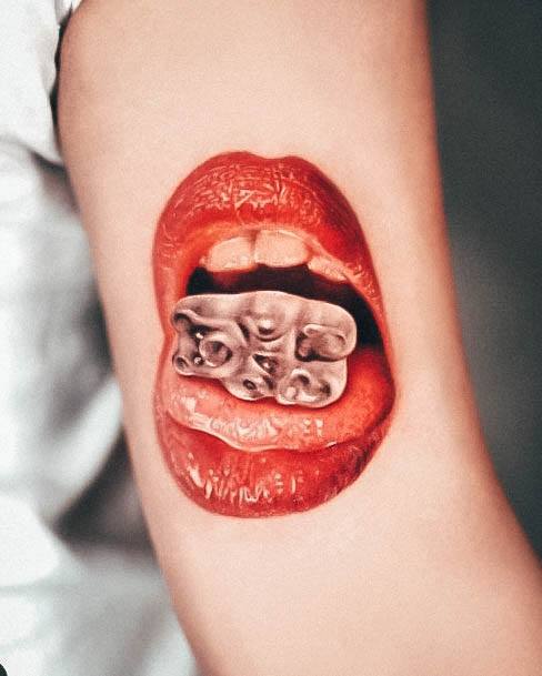 Excellent Girls Realistic Mouth Eating Gummy Bear Tattoo Design Ideas
