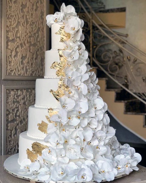 Fairy Tale Tall Tiered White Cake With Cascading White Florals And Gold Accents Design