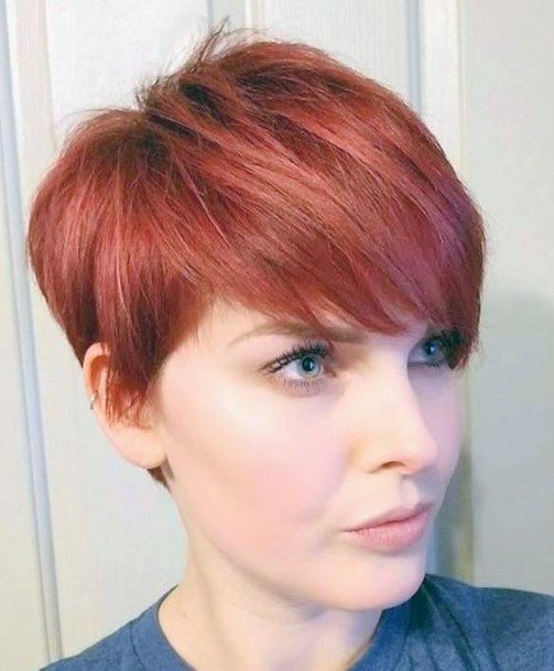 Female Edgy Short Hairstyle With Shaved Neckline And Bright Red Color