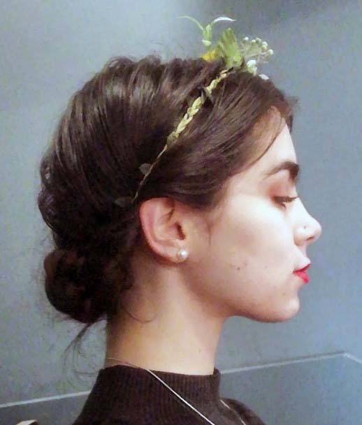 Female With Low Bun Hairstyle And Floral Hair Accessory