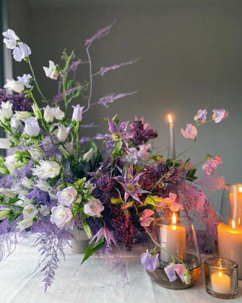 Lighted Candles And Purple Wedding Flowers