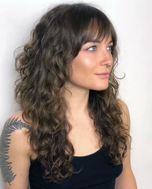 Long Haired Female With Medium Curls Throughout And Blunt Cut Bangs