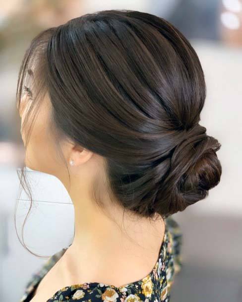 Luxurious Dark Brown Highlighted Polished Low Bun Updo Womens Hairstyle