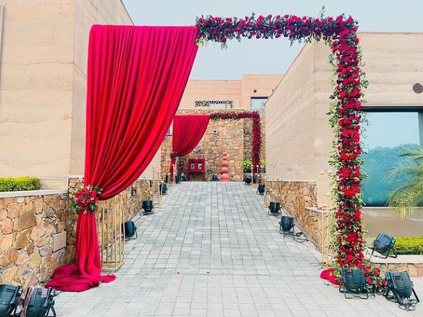 Red Curtains And Roses Welcome Angled Arch Indian Wedding Flowers