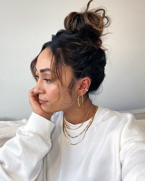 Striking Woman With Brown Hair In A Loosely Top Knot Hairstyle