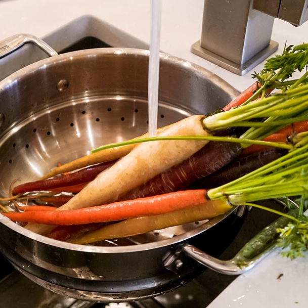 Washing Carrots In Strainer Bowl With Water
