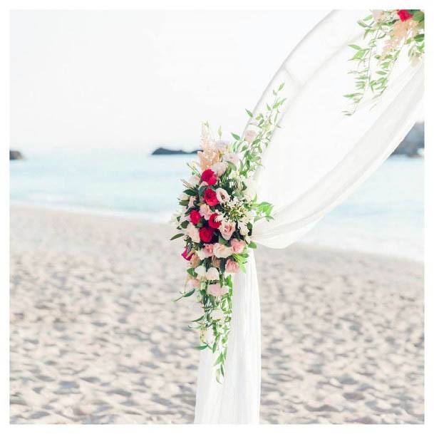 White Arch With Red Beach Wedding Flowers