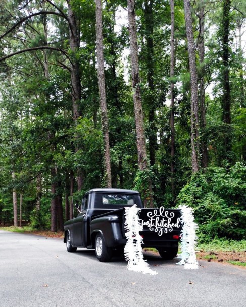 White Decorations On Black Car Wedding