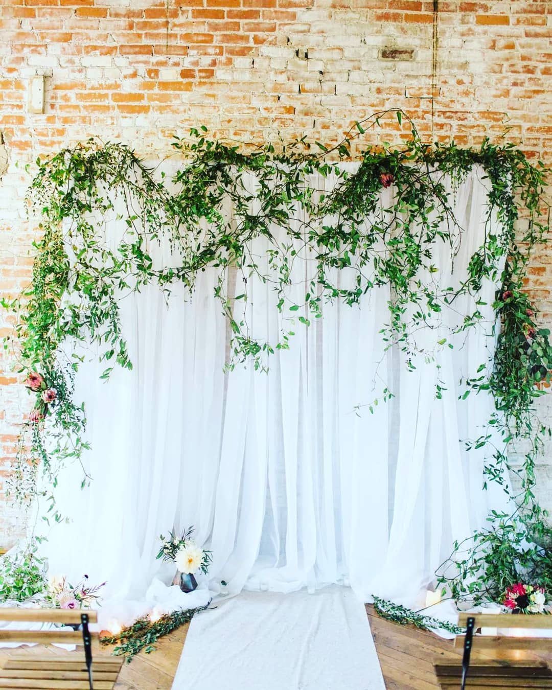 White Draped Wedding Backdrop With Draped Greenery